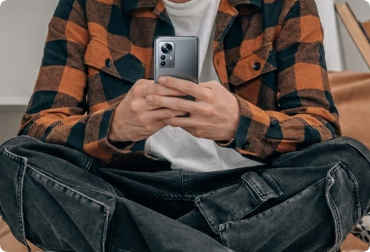 Detalle de las manos de un usuario analizando el diseño, cámaras y ergonomía de un smartphone de gama alta.